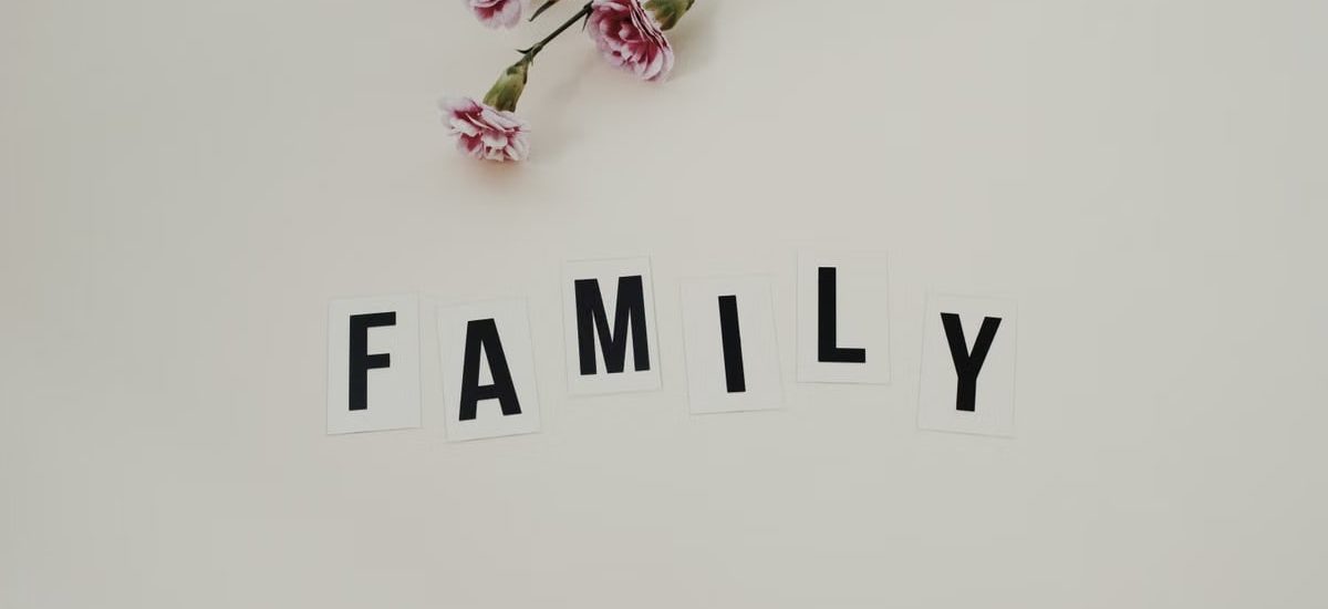 Elegant arrangement of pink flowers and family text on a white background, ideal for family themes.
