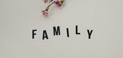 Elegant arrangement of pink flowers and family text on a white background, ideal for family themes.